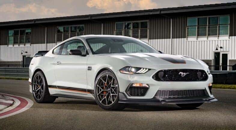 A white 2023 Ford Mustang Mach 1 is shown from the front at an angle.