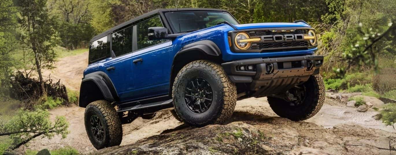 A blue 2025 Ford Bronco Raptor is shown off-road.