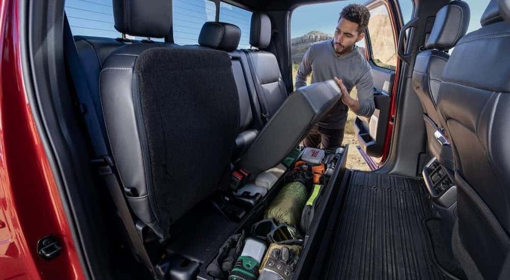 Rear under-seat storage is shown in a red 2025 Ford F-150.