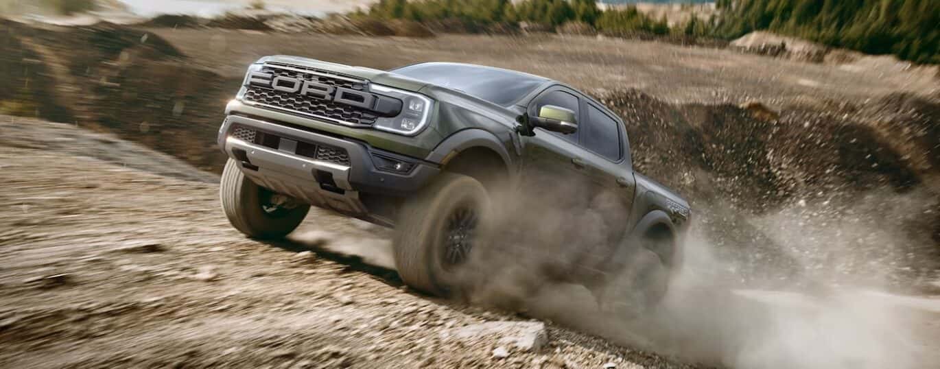 A green 2025 Ford Ranger Raptor is shown off-roading.