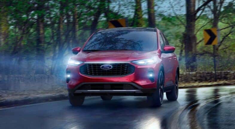 Head-on view of a red 2025 Ford Escape driving in the rain.
