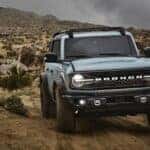 A grey 2021 Ford Bronco driving off-road in a desert.