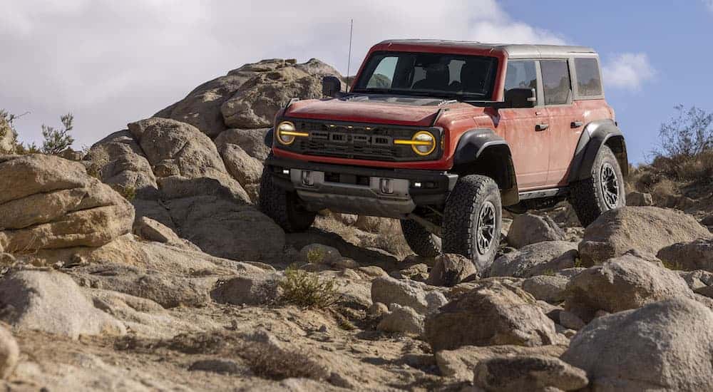 A red 2025 Ford Bronco Raptor is shown from the front at an angle.