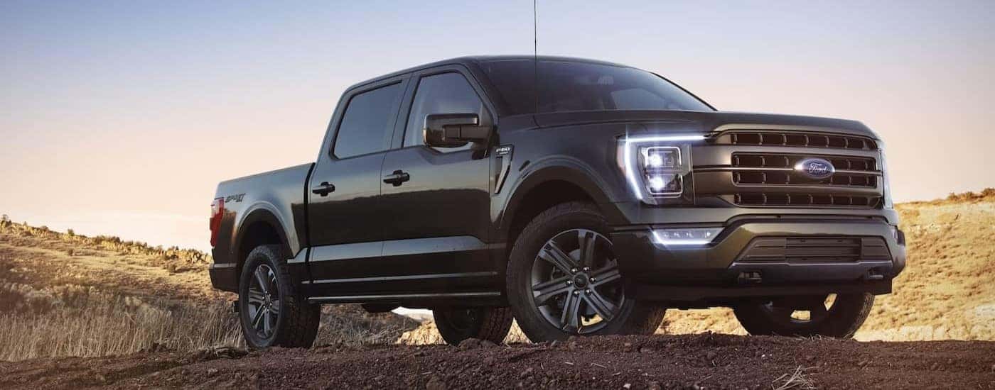A black 2023 Ford F-150 is shown parked off-road after viewing a used Ford F-150 for sale near Schenectady.