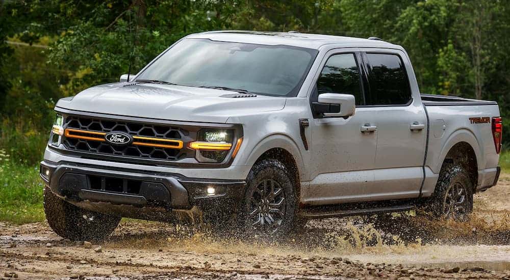 A silver 2025 Ford F-150 Tremor off-roading on dirt.