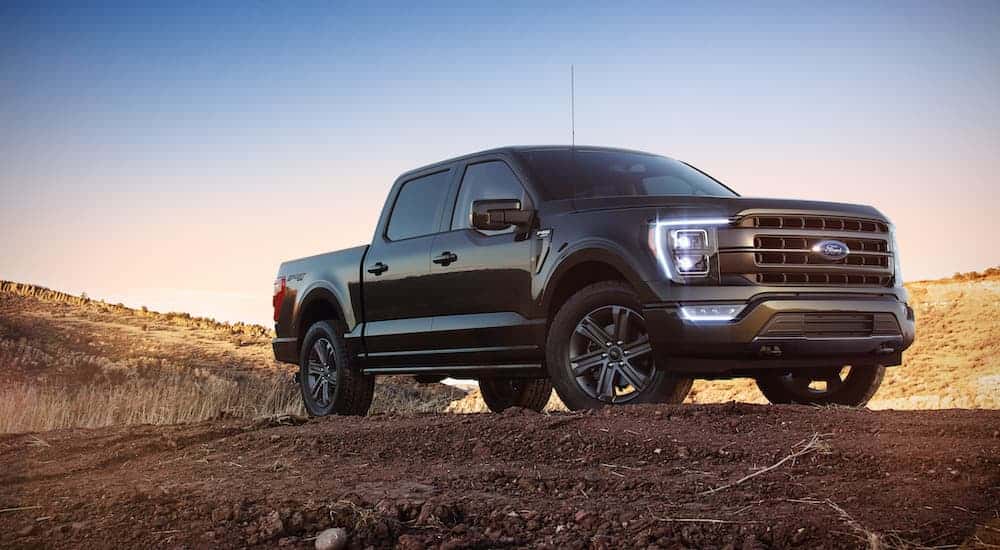 A black 2022 Ford F-150 is shown from the front after leaving a dealer that has a used Ford for sale near Cohoes.