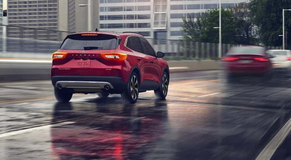 A red 2025 Ford Escape Platinum driving on a rainy day.