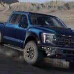 A dark blue 2025 Ford F-150 driving off-road down a hill.