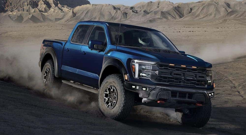 A dark blue 2025 Ford F-150 driving off-road down a hill.