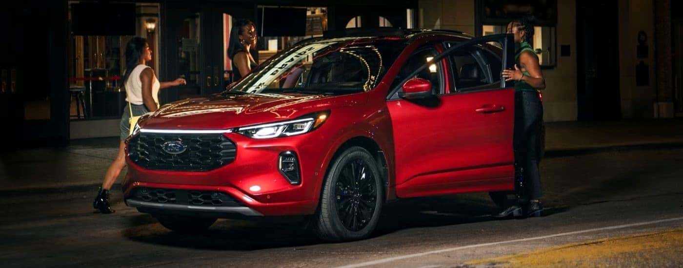 A red 2023 Ford Escape ST-Line Elite parked by a city curb.