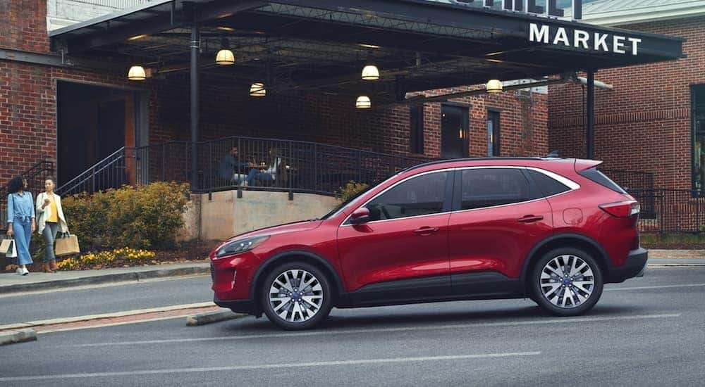 Side view of a red 2020 Ford Escape parked outside a market.