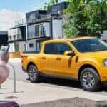 A yellow 2022 Ford Maverick parked by a curb after visiting a dealer with a used Ford for sale near Mechanicville.