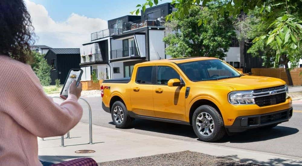 A yellow 2022 Ford Maverick parked by a curb after visiting a dealer with a used Ford for sale near Mechanicville.