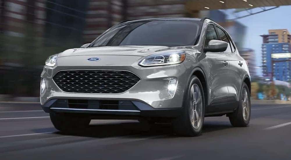 A silver 2020 Ford Escape driving on a city street.