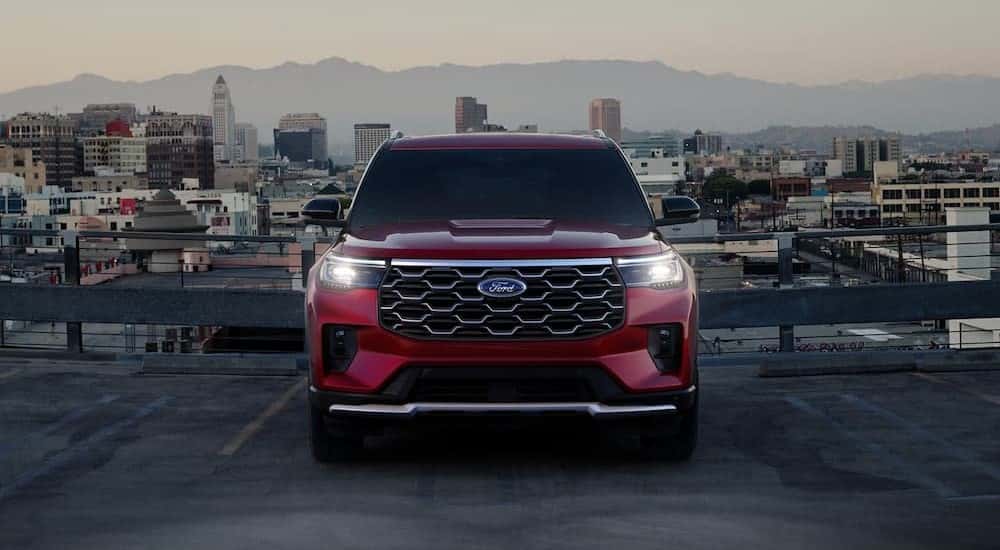 A red 2025 Ford Explorer parked near a city.