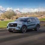 A blue 2025 Ford Explorer ST driving on a highway.