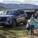 A blue 2025 Ford Explorer ST parked near a lake.