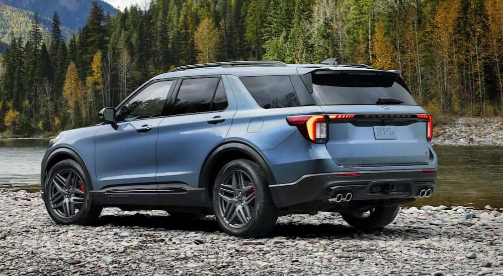 A blue 2025 Ford Explorer ST Line parked off-road.