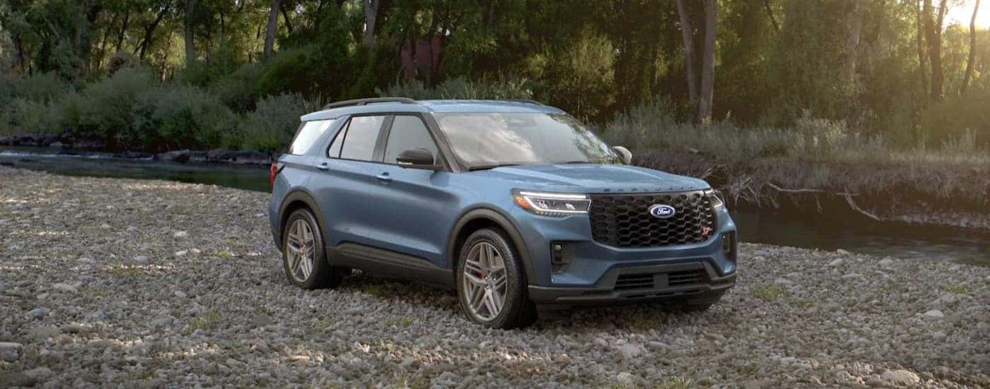 A blue 2025 Ford Explorer ST parked off-road.