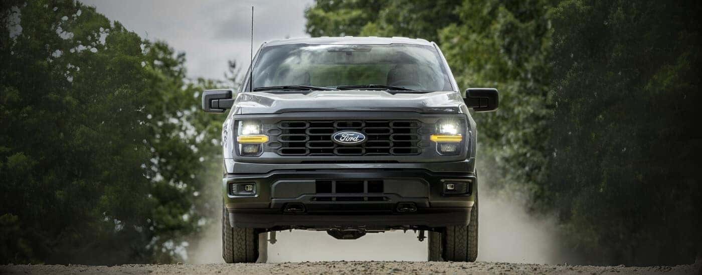 A gray 2025 Ford F-150 STX driving off-road.