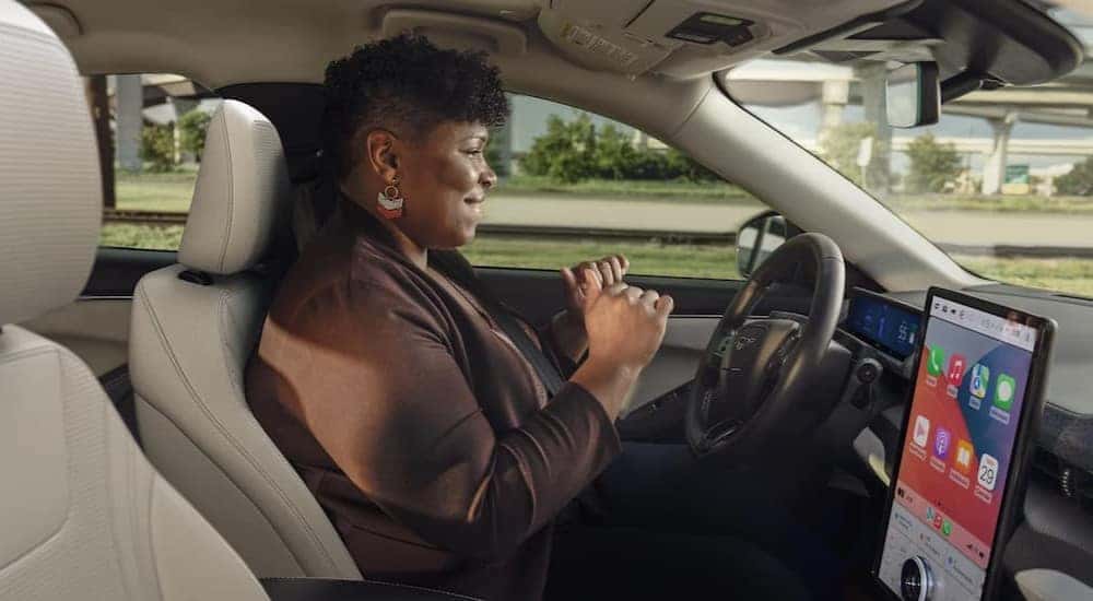 A person driving in a 2025 Ford Mustang Mach-E.