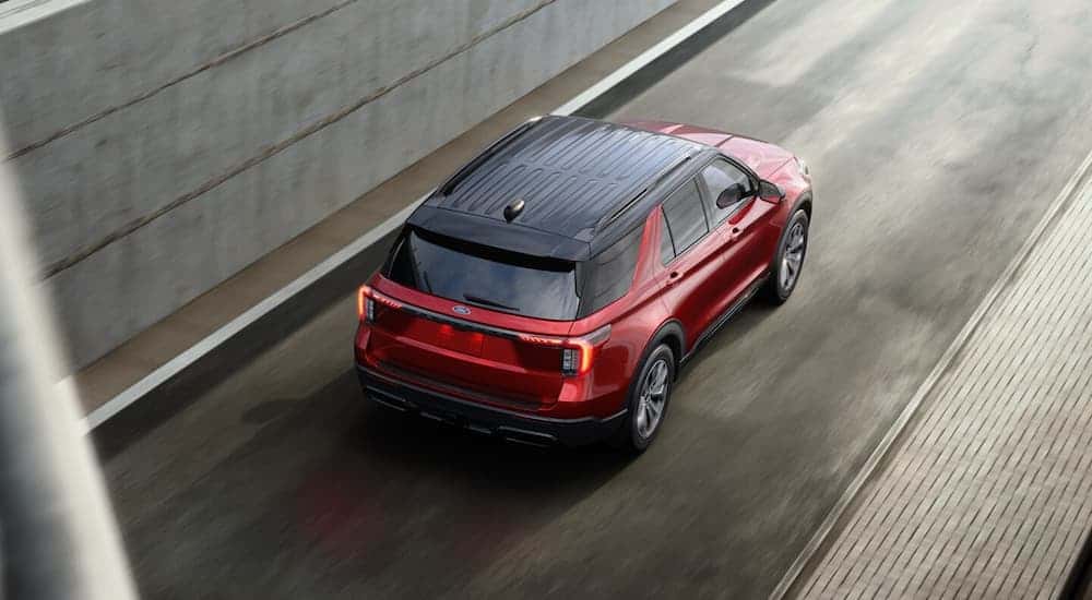 Red 2025 Ford Explorer for sale near Latham on a highway test drive.
