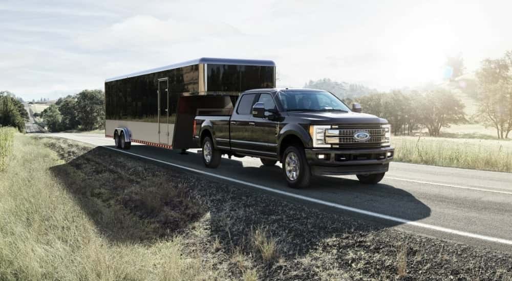 A black 2017 Ford F-350 Platinum towing a trailer.