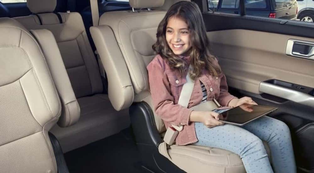 A child sitting in the rear seating are of a 2023 Ford Explorer.
