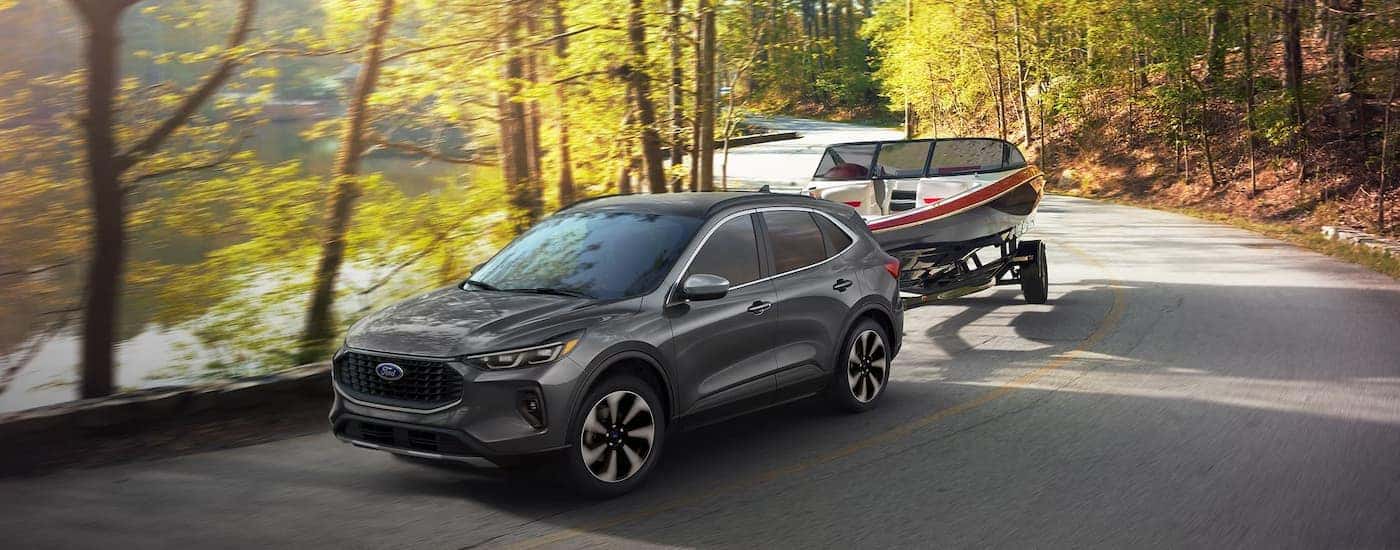 A gray 2025 Ford Escape towing a boat