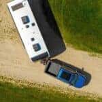 Top down view of a blue 2025 Ford F-150 driving on a dirt road