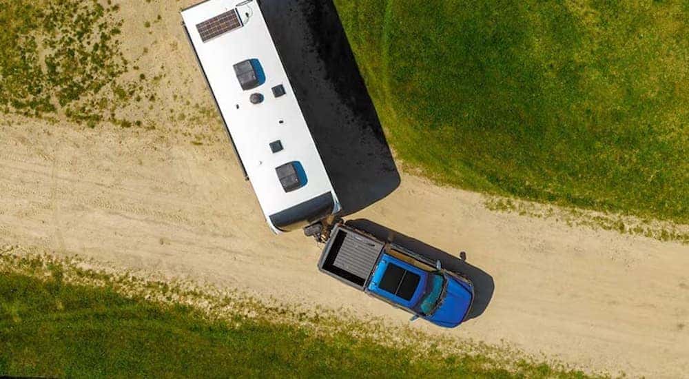 Top down view of a blue 2025 Ford F-150 driving on a dirt road
