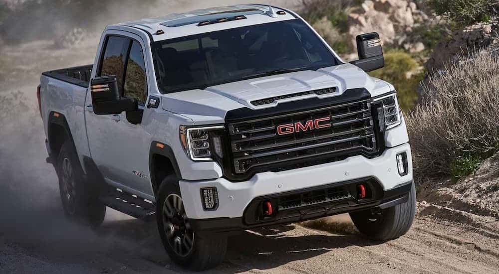A white 2023 GMC Sierra 2500 AT4X driving off-road.