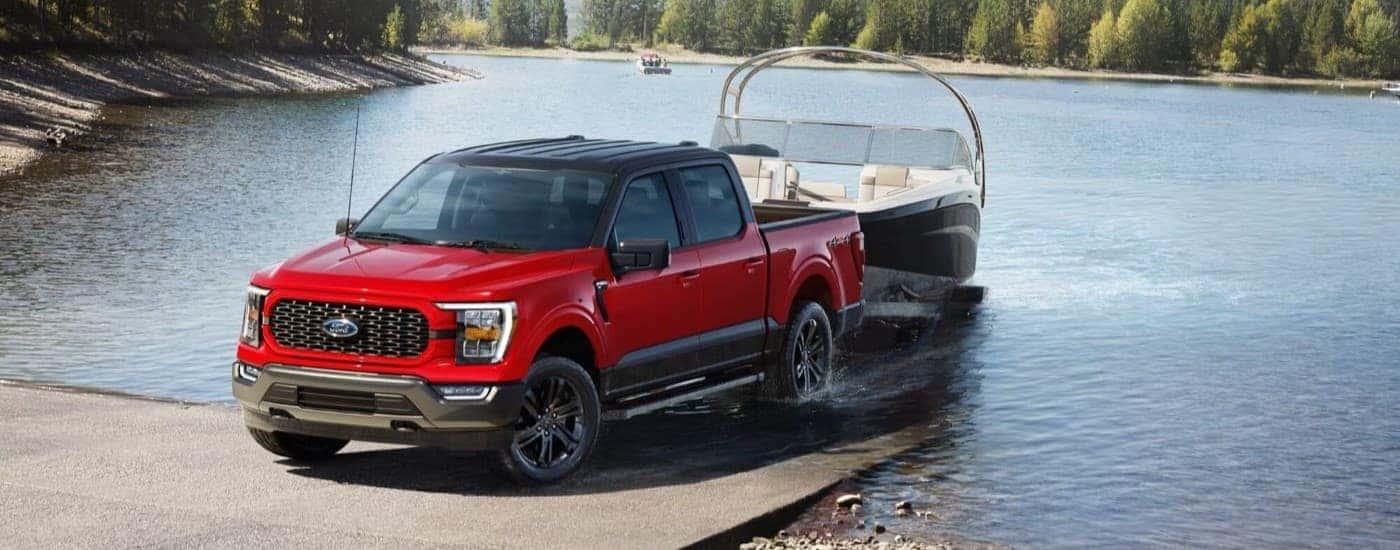 A red 2025 Ford F-150 XLT towing a boat