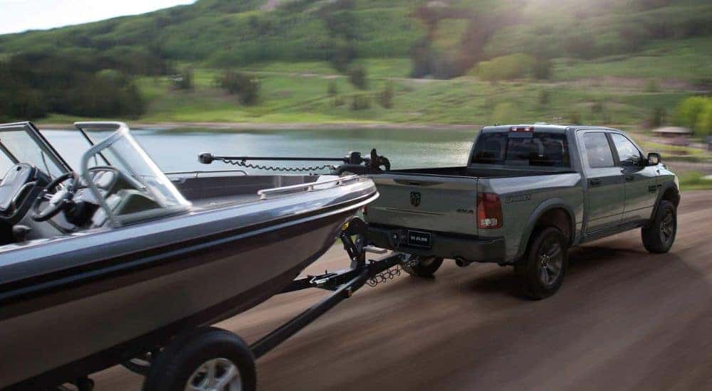 A 2023 Ram 1500 Classic Warlock towing a boat behind