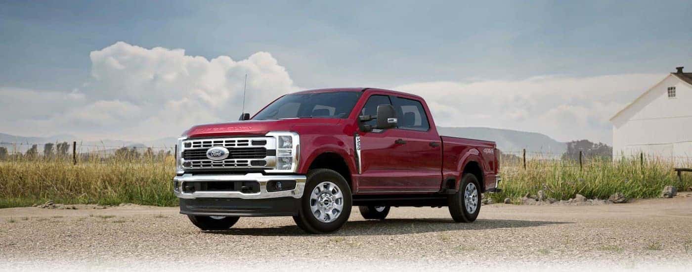 A red 2025 Ford F-250 parked near a field.