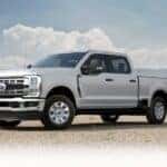 A white 2025 Ford F-250 parked near a field.