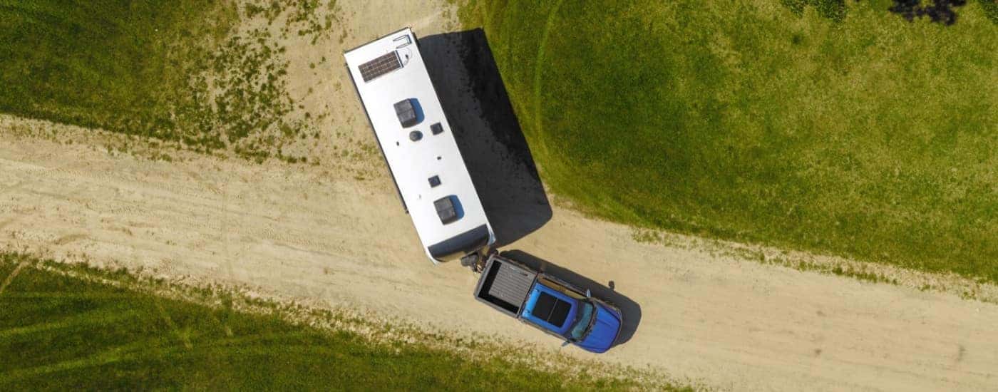 A blue 2024 Ford F-150 towing a trailer.