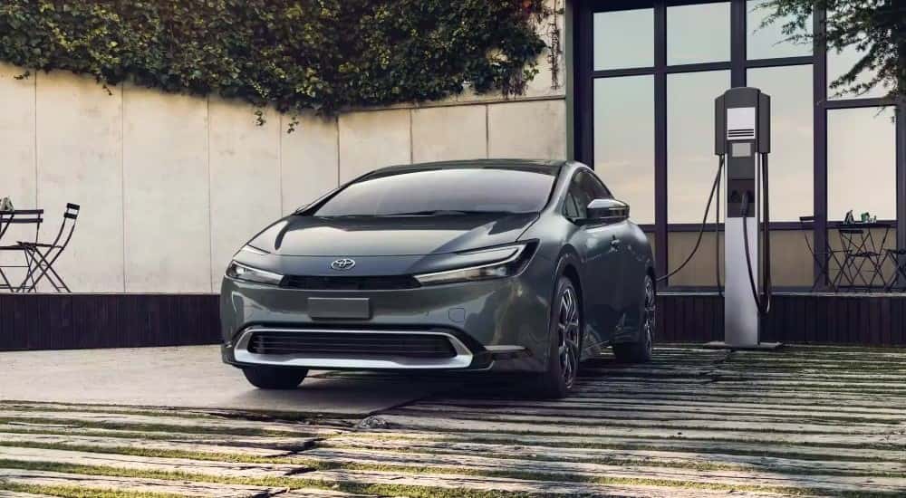 A gray used 2023 Toyota Prius Prime XSE plugged in to charge
