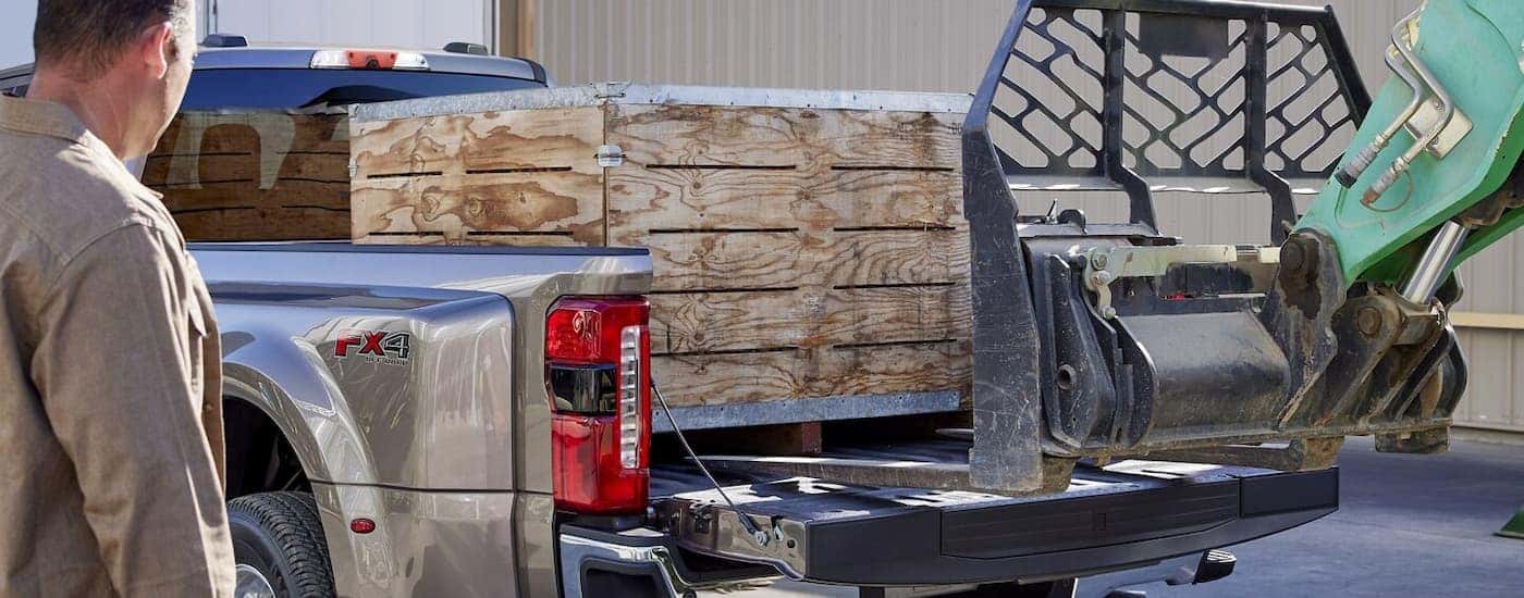 Supplies being loaded into the bed of a silver 2025 Ford F-350