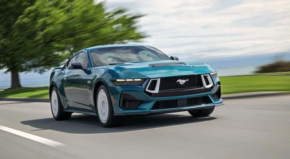 A blue 2026 Ford Mustang driving down a street