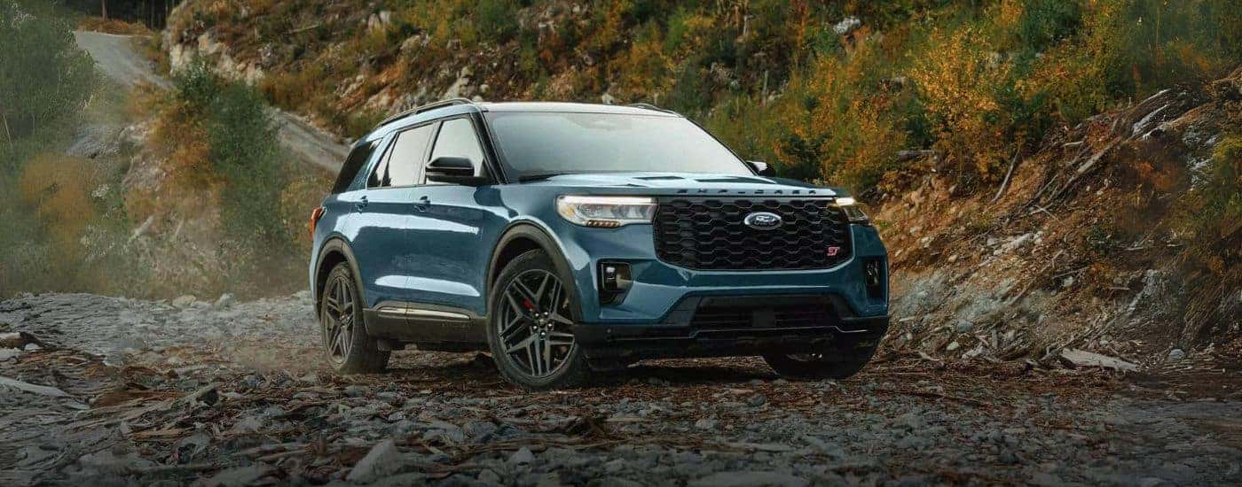 A blue 2025 Ford Explorer ST parked off-road on rocks