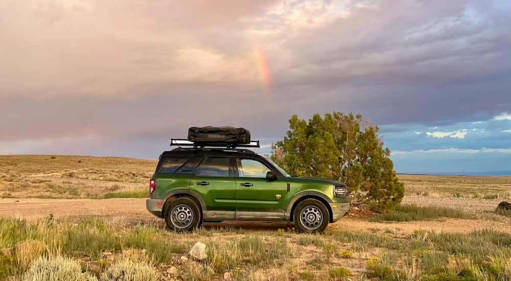 Side profile of green 2025 Ford Bronco Sport driving off-road.