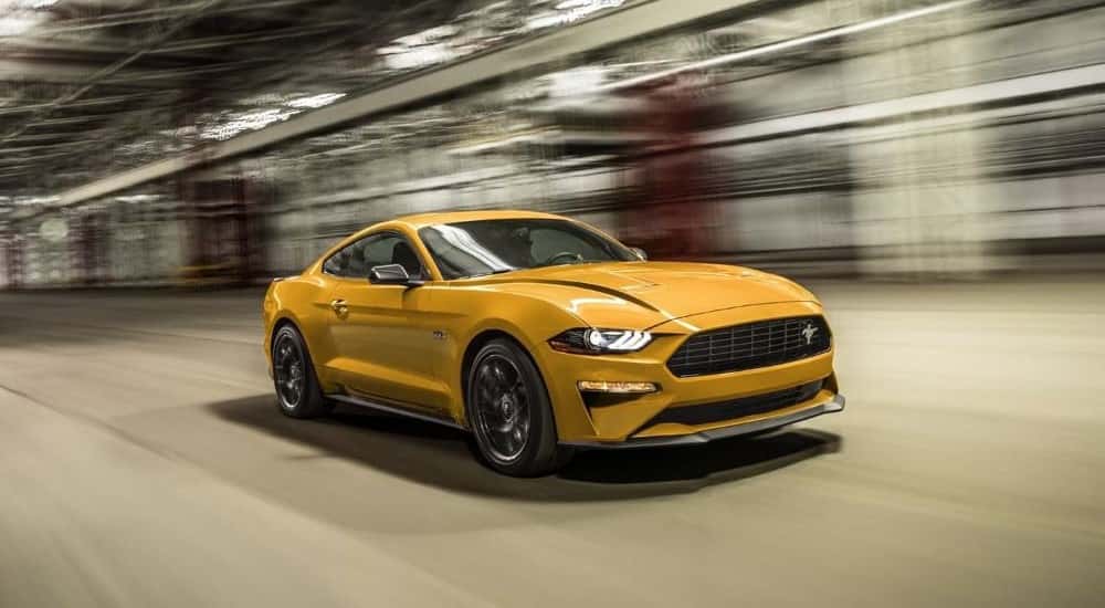 A yellow 2022 Ford Mustang GT driving, one of the many used cars for sale near Halfmoon.