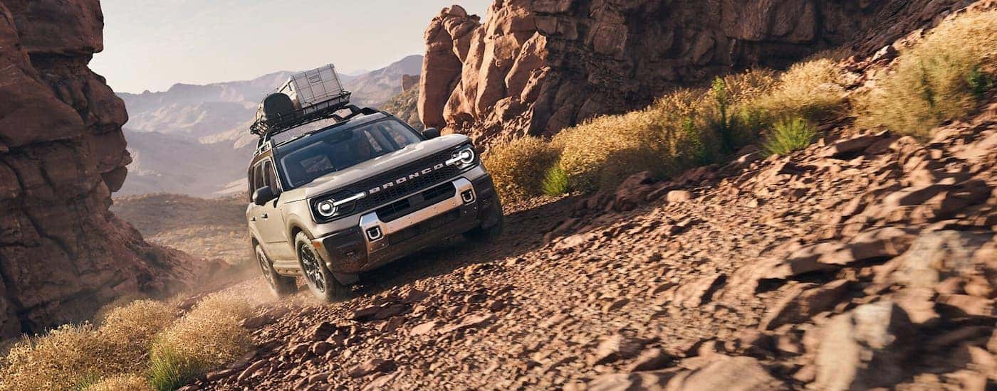 A tan 2025 Ford Bronco Sport off-roading on rocky terrain