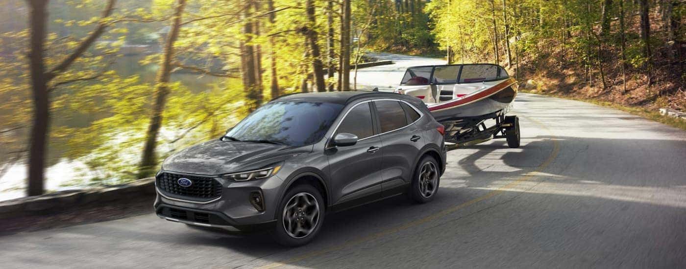 A gray 2025 Ford Escape towing a boat