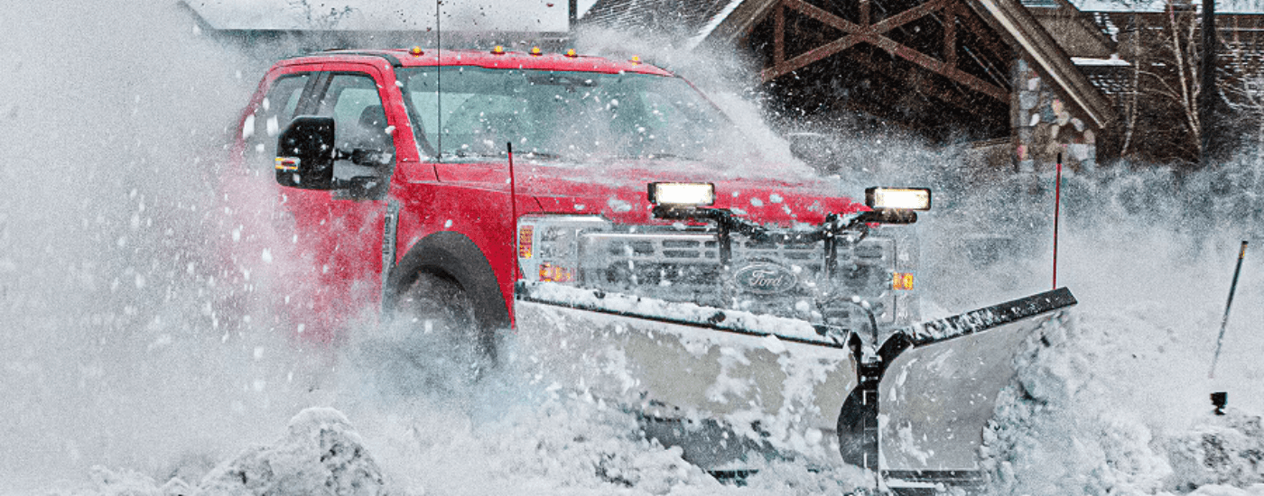 Red 2026 Ford F-450 plowing snow