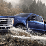 Blue 2026 Ford F-250 Super Duty driving through a creek