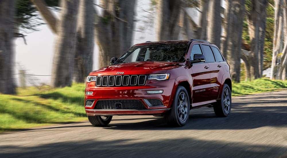 Red 2020 Jeep Grand Cherokee driving down a dirt road