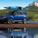 Blue 2010 Ford Escape parked by water with a kayak