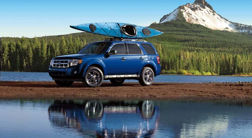 Blue 2010 Ford Escape parked by water with a kayak